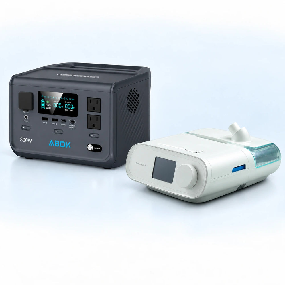 ABOK Ark300 portable power station beside a DreamStation Auto DSX500 CPAP machine on a pale blue and white background.