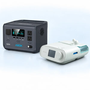 ABOK Ark300 portable power station beside a DreamStation Auto DSX500 CPAP machine on a pale blue and white background.