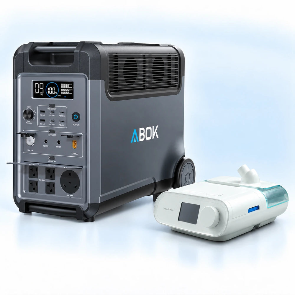 ABOK Ark3600 portable power station beside a DreamStation Auto DSX500 CPAP machine on a pale blue and white background.